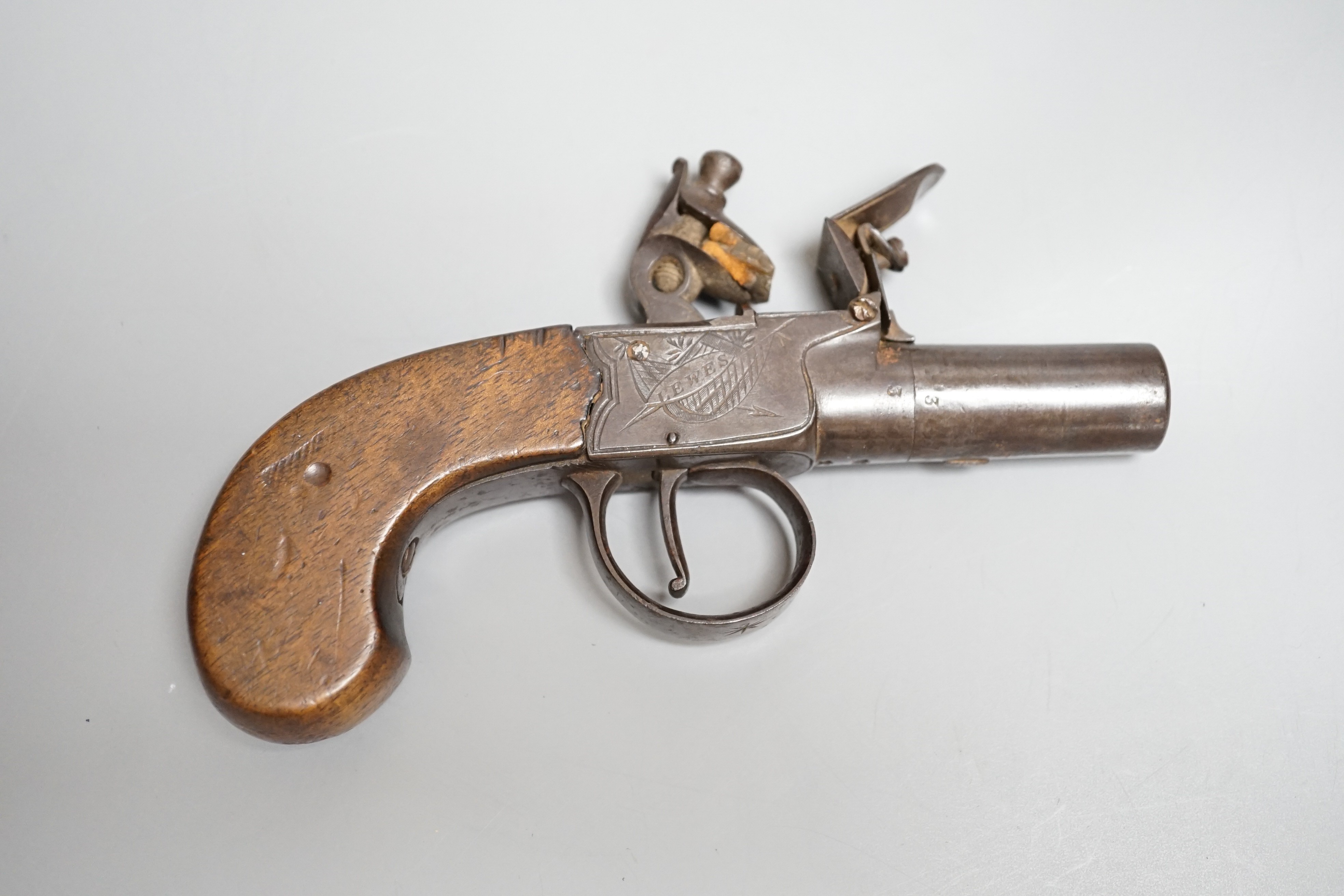 A Flintlock pocket pistol signed Lowdell & Co. Lewes, early 19th century, turn off barrel, signed action engraved with trophies, walnut grip, length 15.5cms